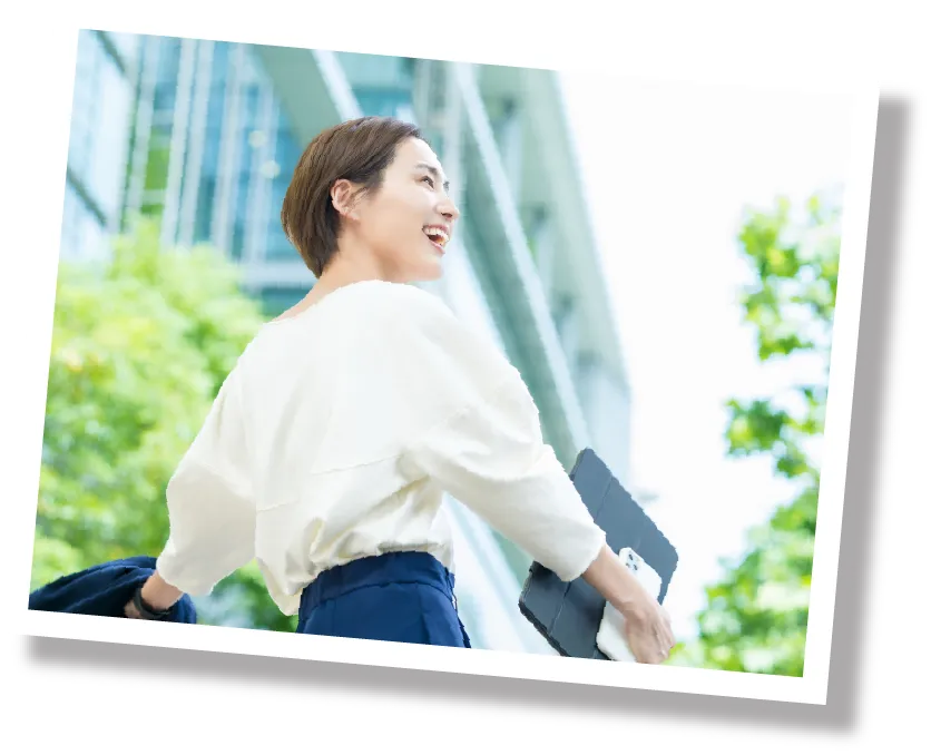 オフィス街を笑顔で歩く女性